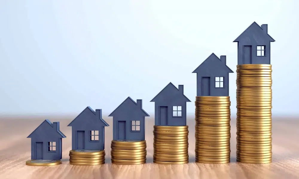 Tiny model houses sitting on coins