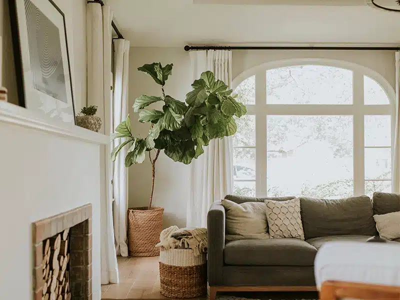 Interior of a short-term rental living area with large windows and a fireplace.