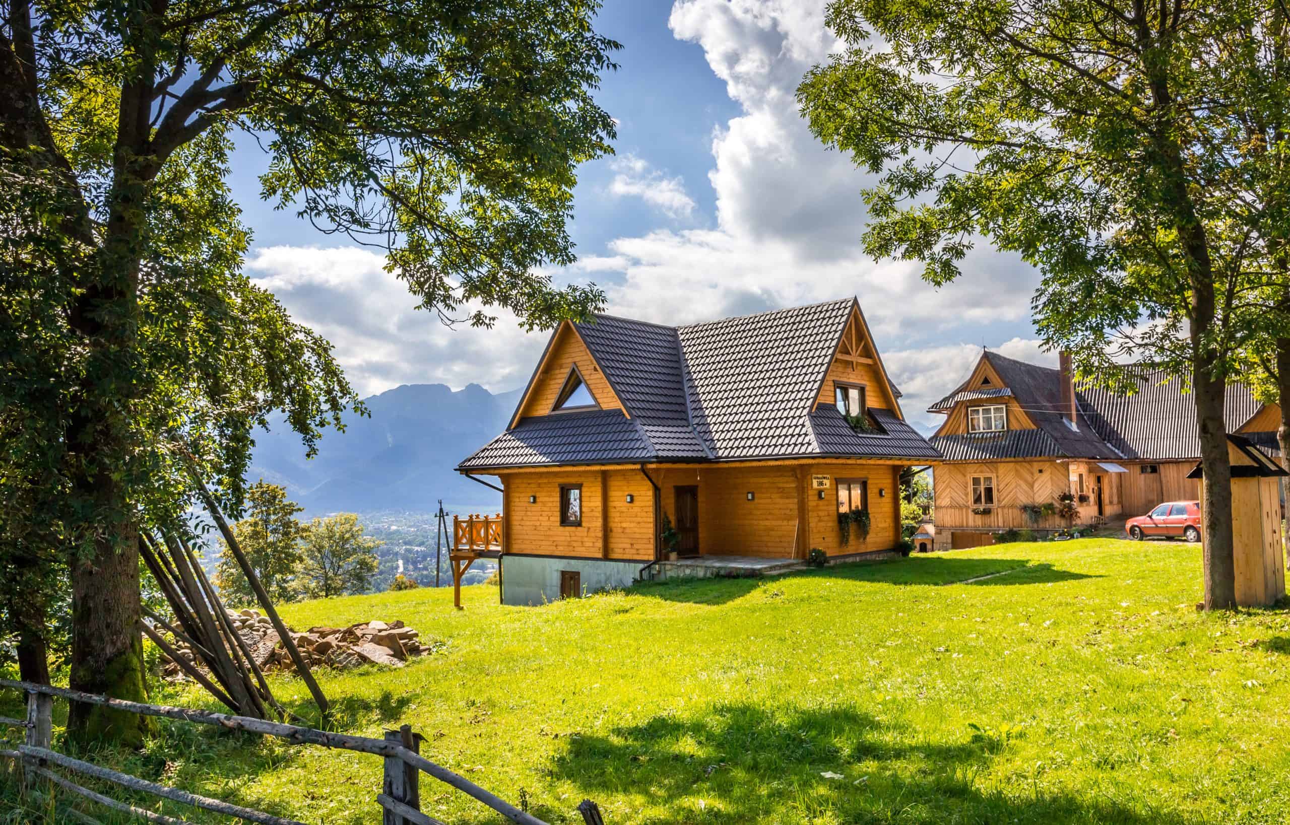 The exterior of a mountain cabin home in the summer.