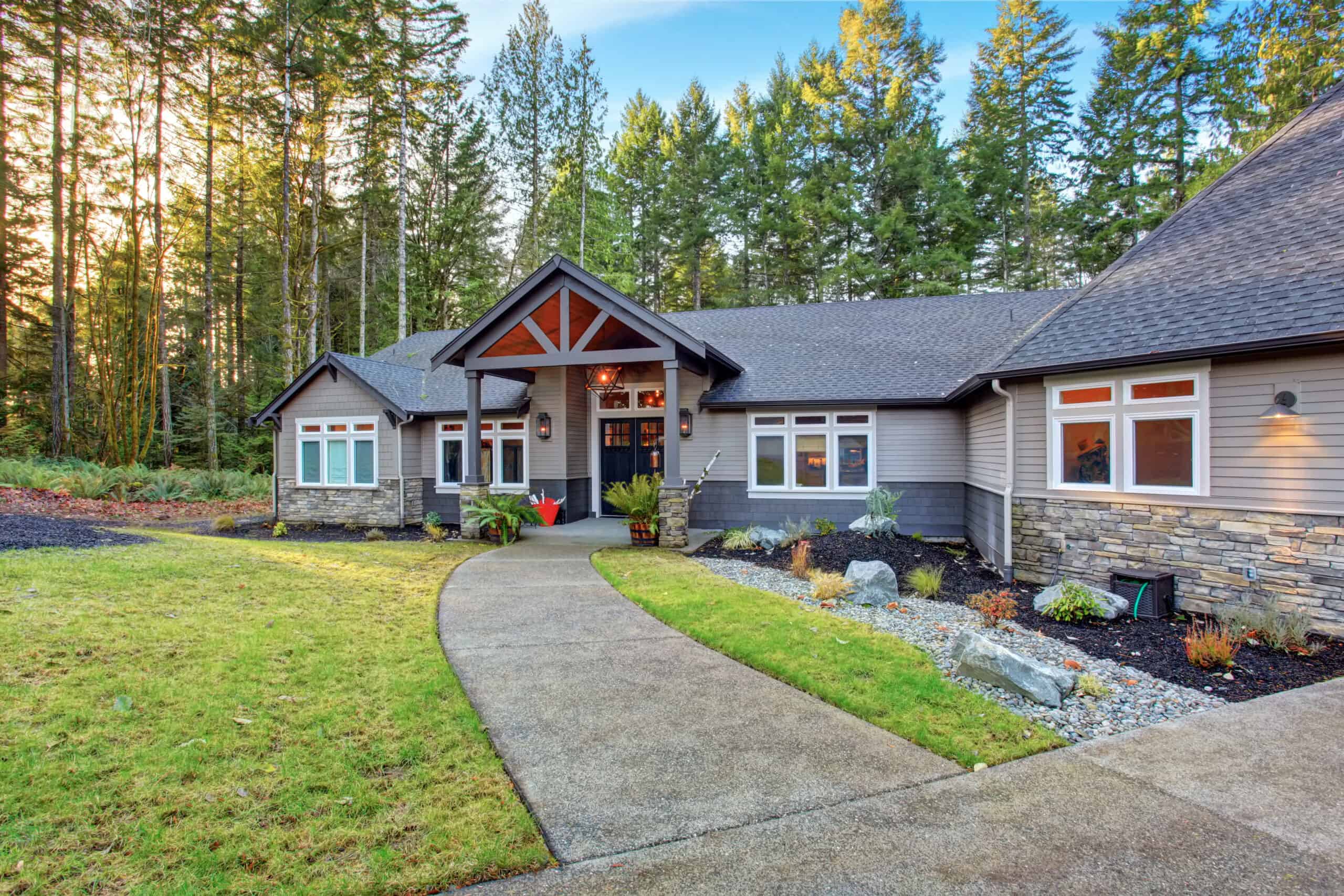 The exterior of a brick home nestled in front of trees.