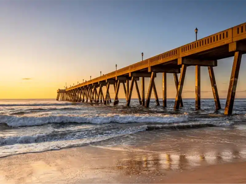 Beach with a yellow glow and a pier